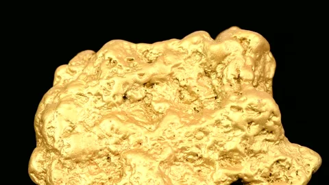A nugget of gold moves on black surface. Top view. Stock Footage 154814729