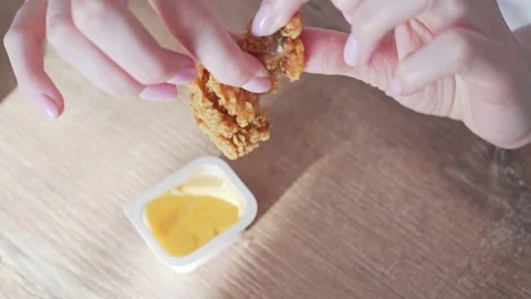 Nuggets are broken and dipped in sauce. Chicken fast food, fried wing in Stock Footage 132355528