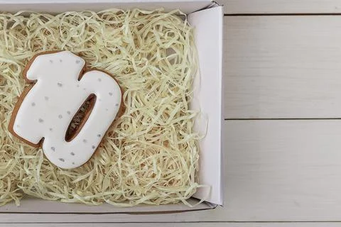 Number 10 shape gingerbread cookie on present box on white wooden table Stock Photos