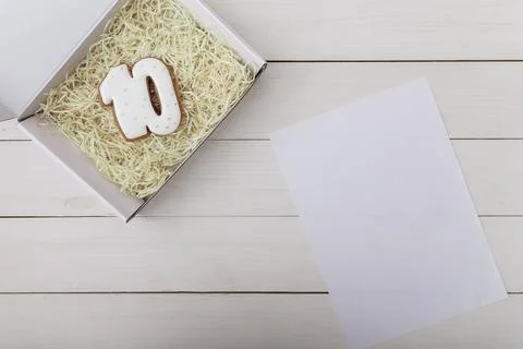 Number 10 shape gingerbread cookie on present box on white wooden table Foto stock