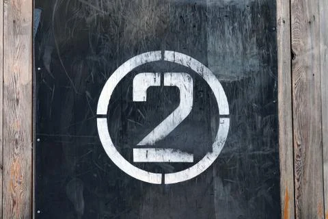 Number 2 in circle, on old rubber banner on stadium wall. White winner stamp Stock Photos