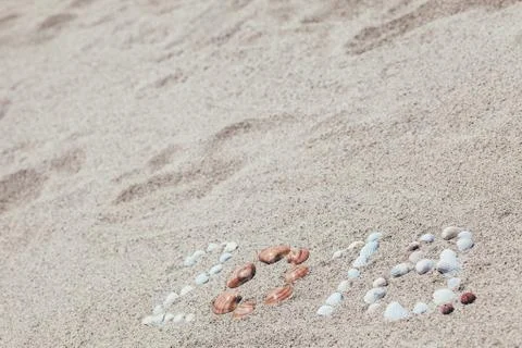 Number 2018 written with shells on the sand Stock Photos