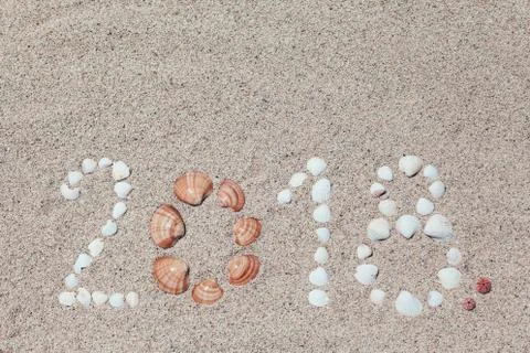 Number 2018 written with shells on the sand Stock Photos