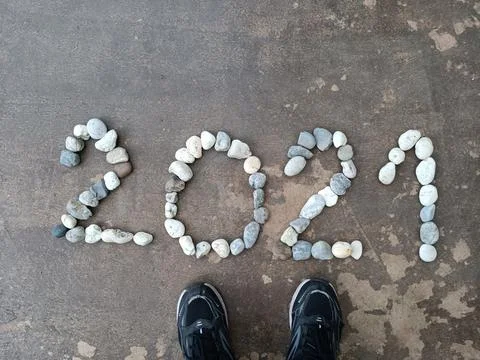 The number 2021 is lined with rocks on the surface and shoes Stock Photos
