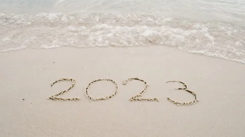 Number 2022 write on sandy beach, ocean wave splash change to 2023 for new year Stock Footage 221476339