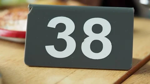 Number 38 stands on a table in a busy cafe setting Stock Footage 335461627
