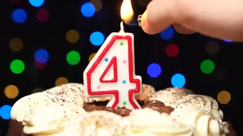 Number 4 on top of cake - four birthday candle burning - blow out at the end Stock Footage 85129749
