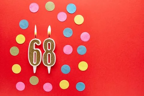 Number 68 on a red background with colored confetti. Happy birthday candles.. Stock Photos