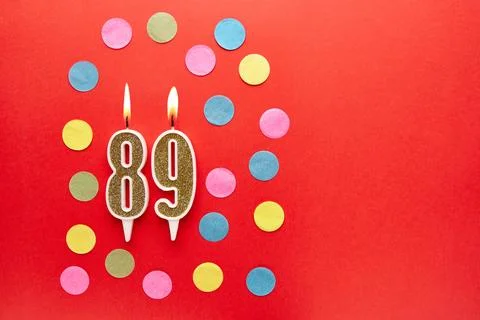 Number 89 on a red background with colored confetti. Happy birthday candles.. Stock Photos