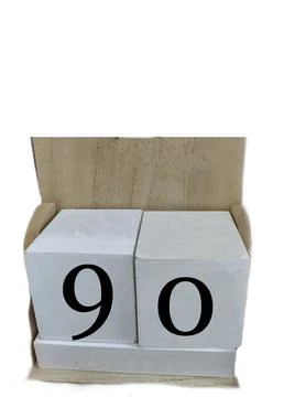 Number 90 on two cubes placed in a wooden support Stock Photos