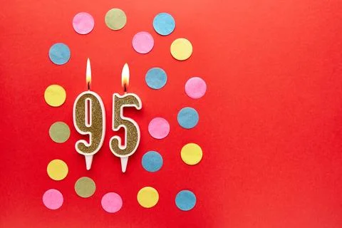 Number 95 on a red background with colored confetti. Happy birthday candles.. Stock Photos