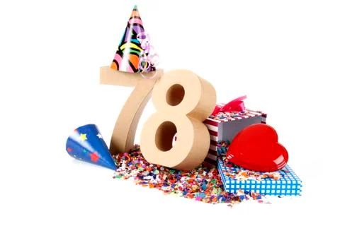 Number of age in a colorful studio setting with paper party hats, a red heart Foto stock
