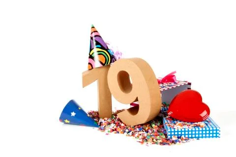 Number of age in a colorful studio setting with paper party hats, a red heart Stock Photos