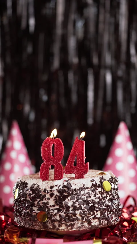 Number eighty-four birthday candle on sweet cake on dark background, 84th 스톡 동영상 270155739