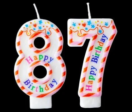 Number eighty seven shaped birthday candle with colorful sprinkles and Happ.. Stock Photos