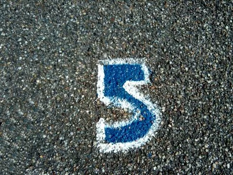 Number five painted on asphalt Stock-Fotos