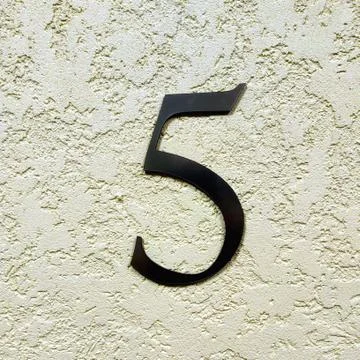 Number five on the wall. Stock Photos