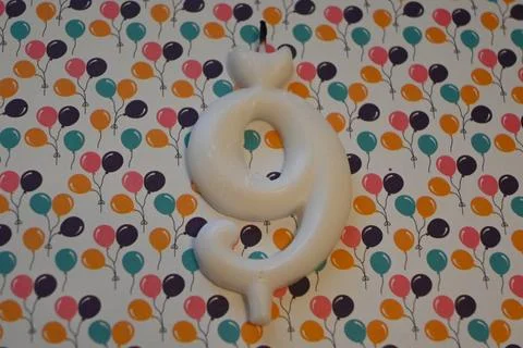 Number nine candle on balloon pattern background Foto stock