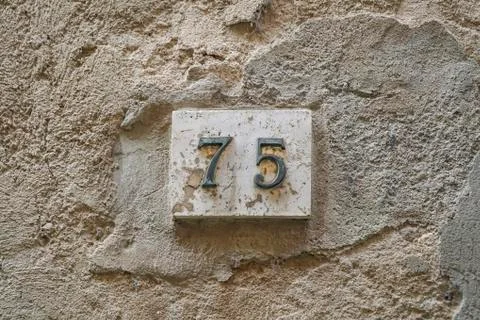 Number seventy five on a wall Foto stock