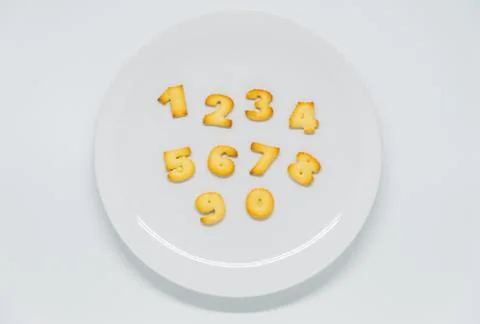 Number shape cracker on dish with white background Stock Photos
