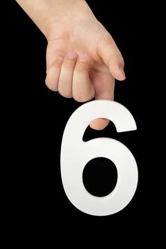 Number six in hand isolated on black background. Number six in a child's hand Stock Photos