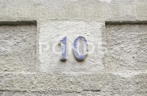 Number ten on a stone wall, detail of a number of information on a wall in th Stock Photos