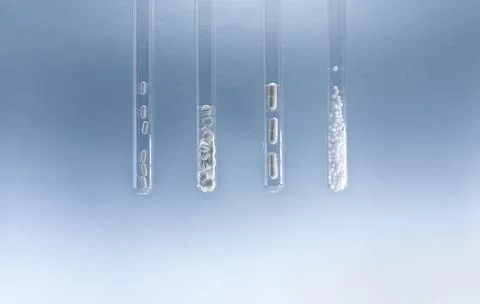 A number of test tubes with different pills on a blue background. 写真素材