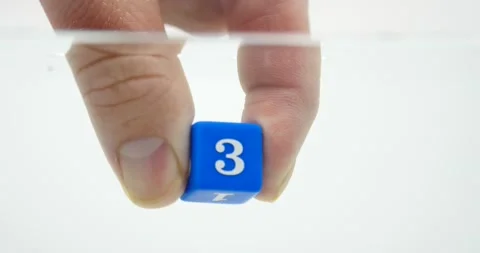 Number three on dice blue being held by fingers isolated on white and water Stock Footage 219520751