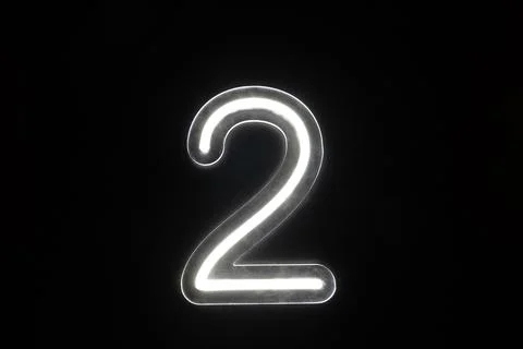 Number two glowing on the dark background. Close up of bright number 2 Stock Photos