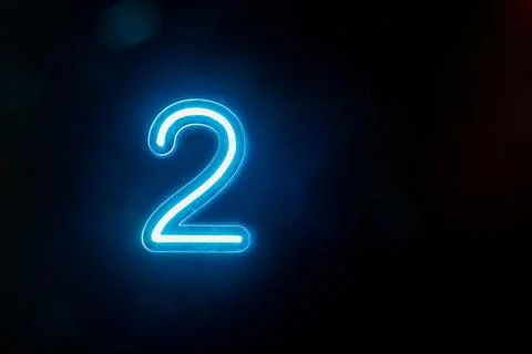 Number two glowing on the dark background. Close up of bright number 2 Stock Photos