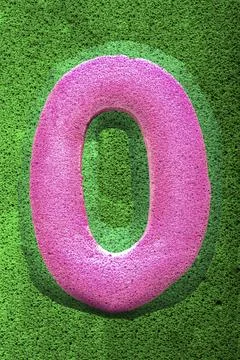 The number zero in a pink sponge like texture, raised 3D from the green Stock Illustration