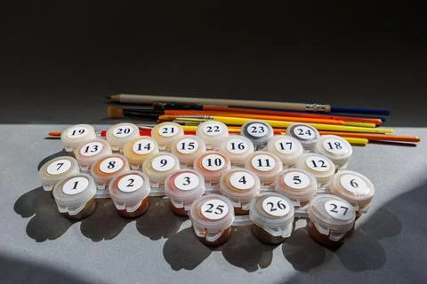 Numbered paint cans and brushes on a gray background. Painting by numbers. .. Stock Photos