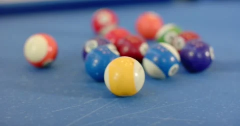 Numbered pool balls are scattering on blue-felt table after unseen cue ball Stock Footage 342492723
