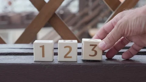 Numbers 1 2 3, laying out  by hand from on wooden cubes Stockbeeldmateriaal 342135108