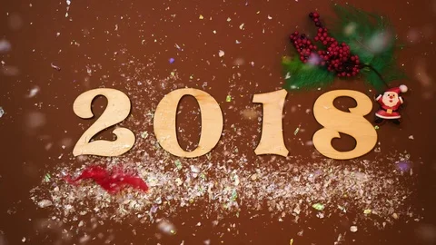 Numbers 2018 on the brown table background the snow is falling from above. Stock Footage 82953376