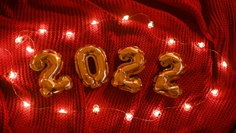 Numbers 2022 on the background of a red knitted cozy plaid and Christmas lights. Stock-Footage 164402840