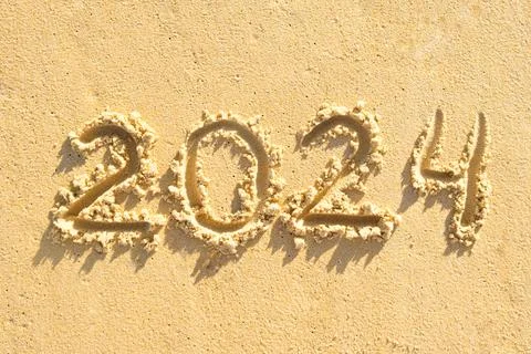 Numbers 2024 handwritten in the sand surface. New year concept Stockfoto's