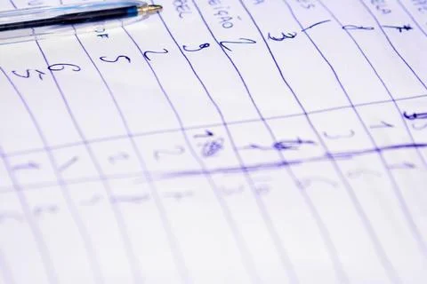 Numbers handwritten on lined notebook page Stock Photos