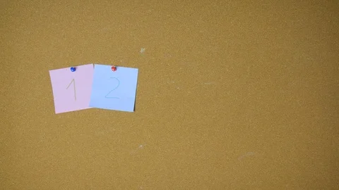 Numbers one to nine and zero Hands pining sticky notes on pin board funny Stock-Footage 98520406