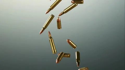 Numerous brass bullets fall and tumble through a grey space Stock Footage 326748584