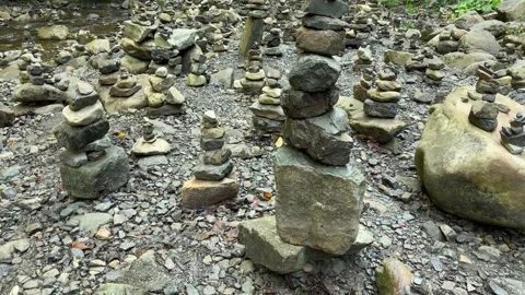 Numerous cairns built on stony mountain stream bank, close-up Stock Footage 300003523