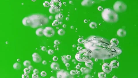 Numerous clear, iridescent soap bubbles float upwards against a bright, Video stock 308694805