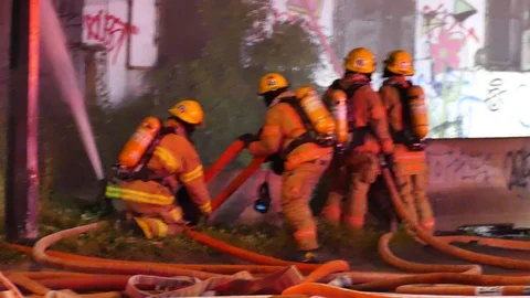 Numerous firefighters with numerous fire hoses Stock Footage 115972560