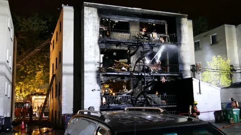 Numerous firefighters working at apartment building Stock Footage 119952243