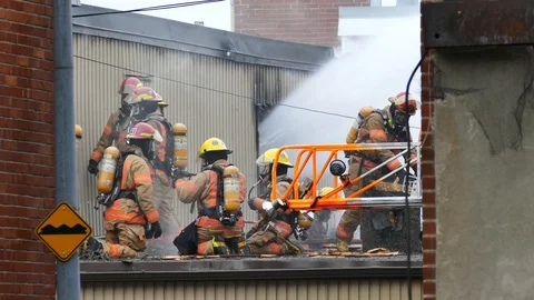 Numerous firemen battling garage fire Stock Footage 120120968
