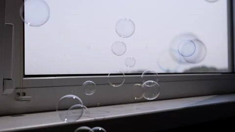 Numerous Rainbow Bubbles Descend onto Bright Windowsill Stock Footage 317561378