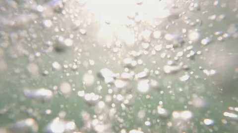 Numerous sparkling bubbles rising underwater in a green liquid, creating an Stock Footage 343076107