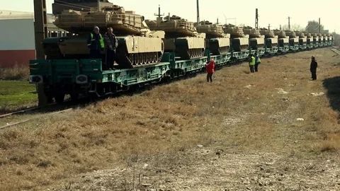 Numerous tanks being transported on a slow-moving train Stock Footage 114019390