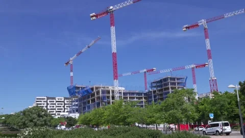 Numerous tower cranes building a concrete edifice 스톡 동영상 335484955