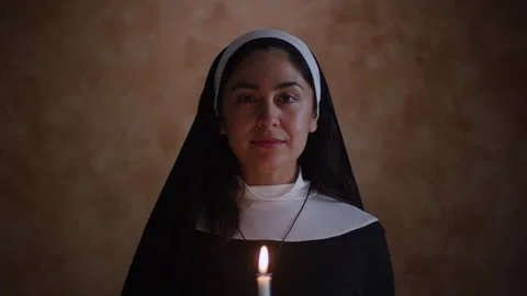 Nun Looking Down at Lit Candle Looks up Видео 270399226